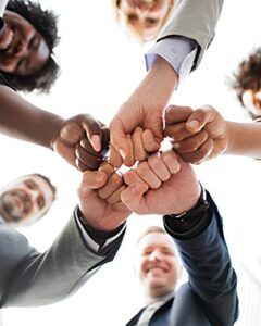Diverse team of US accounting professionals joined in a fist bump symbolizing unified financial solutions